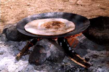 Eritrea - Adi Keshi. Preparing kitcha (traditional Eritrean unleavened bread made from wheat) on a charcoal fire.