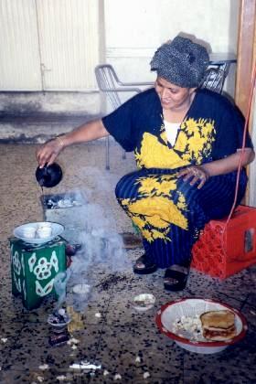Lady bartender Alghanesh Alem making coffee the Eritrean way - Medeber Asmara Eritrea.