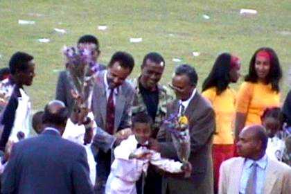 President Isaias Afwerki breaks hembesha, Eritrean bread, on the back of a boy, to wish him all the best on his tenth anniversary.