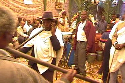 Woman beating the drums in front of the party tent.