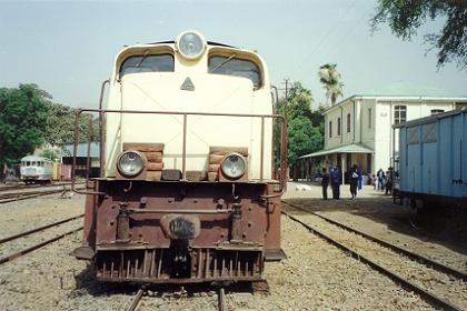 The train at Ghinda railway station with old Italian railcar on the background.