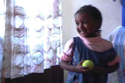 Solomon's daughter Eden, happy with the tennis ball I brought her.