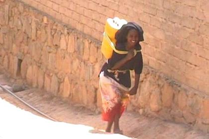 Carrying water from Ghinda's central water supply.