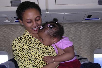 Eritrean Airlines flight attendant comforting an impatient kid.