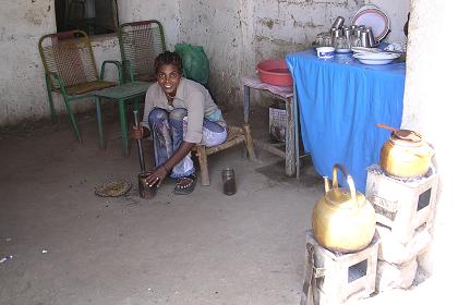 Woman grinding coffee in a little tea and coffee shop - Haykota Eritrea.