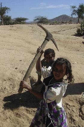 Young girl showing off with a pickaxe - Keren Eritrea.