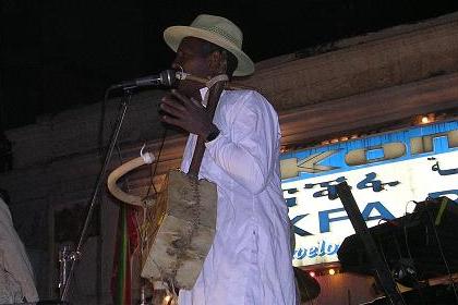 Tigre singer with traditional - violin like - instrument (Wata). Harnet Avenue Asmara Eritrea - 14th Independence Day.