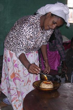 Yordanos preparing ga'at, a small volcano made of poridge with a butter and berbere sauce in the middle - Sembel Asmara Eritrea.