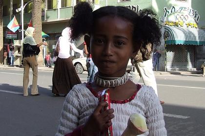 Young girl eating ice cream - Harnet Avenue Asmara Eritrea.
