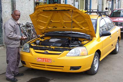 Taxi driver polishing the engine of his Hyundai Kia taxi.