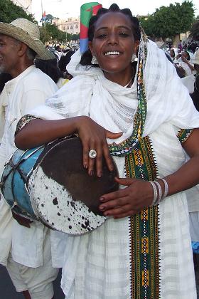 Traditionally dressed woman, playing the kebero - Independence Day carnival - Asmara Eritrea.